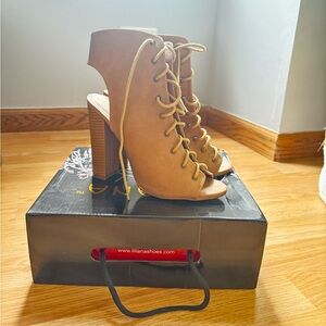 Beige peep toe lace-up heels.